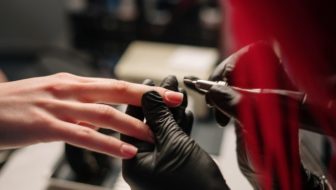 Woman providing nail treatment to its customer in a salon