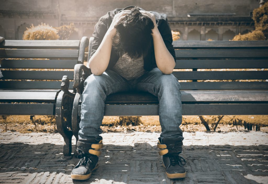 Man sitting depressed on a bench