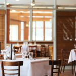 A Restaurant with wooden decor, wooden chairs and tables .