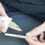 Man holding pre Roll tubes in his hand.