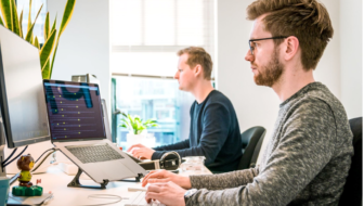 Two men working on softwares on their computers.
