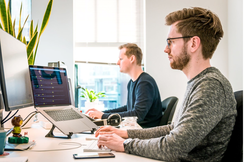 Two men working on softwares on their computers.