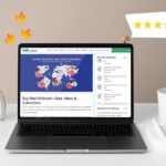 A laptop showcasing Buy Real Media review and a mug placed next to it.