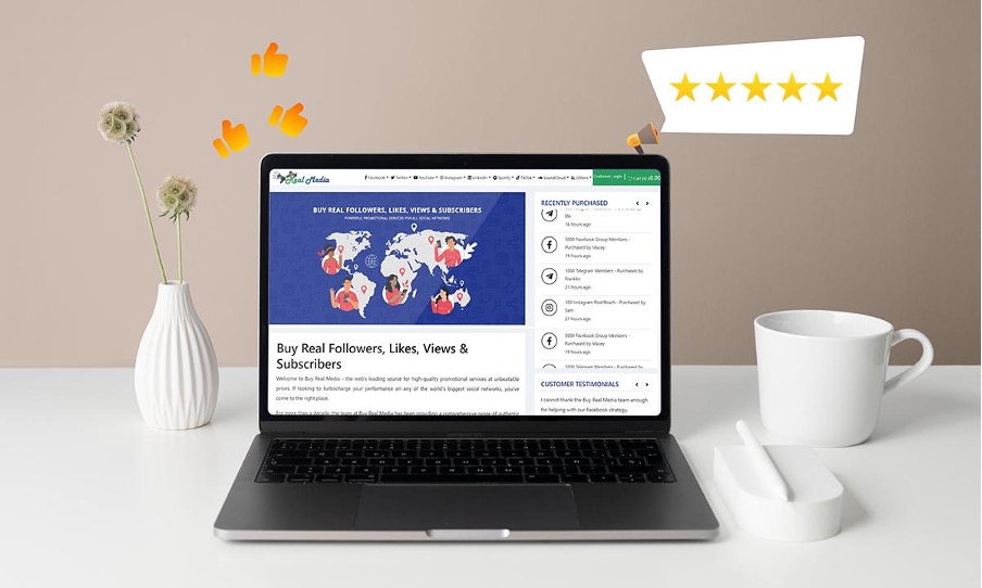 A laptop showcasing Buy Real Media review and a mug placed next to it.
