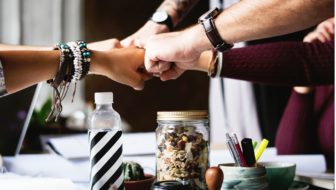 All the employees showing their loyalty by putting their fist forward.