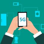 A man holding a phone with 5G network.