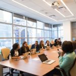A team of members sitting in a board room.