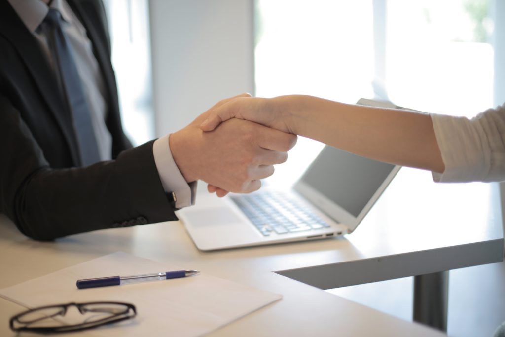 Man shaking hands after hiring a candidate.