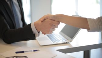 Man shaking hands after hiring a candidate.