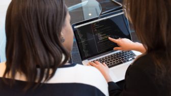 A woman teaching programming to her student