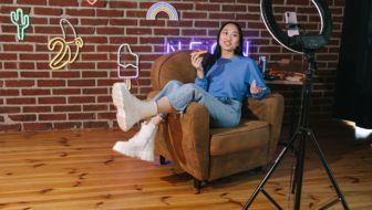 Woman recording a video of her own in a studio.