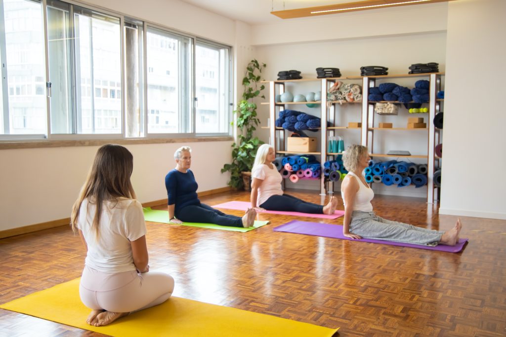 Women performing yoga in a fitness centre.
