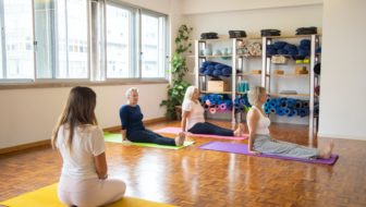 Women performing yoga in a fitness centre.