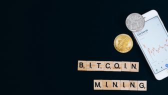 Bitcoins and a mobile placed together.