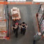 Two employees discussing about warehouse inventory.