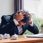 A man holding his head in stress.