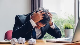 A man holding his head in stress.