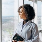 A woman looking outside the office window.