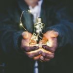 A man holding a light bulb in his palms.