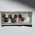 A note and coins placed together.