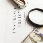 Insurance policy documents and a magnifier.
