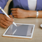 A man jotting down on I-pad.