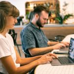 Man and woman working on their laptops.