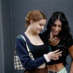 Two women looking in the phone.