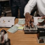 A man calculating and collecting cash.