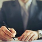 A man writing on a paper.