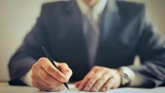 A man writing on a paper.