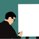 A man writing on a white board.