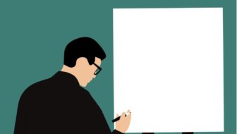 A man writing on a white board.