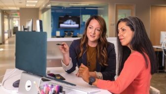 Two women looking at the laptop screen.