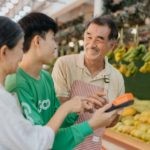 A couple at a farmer’s market stand with the owner