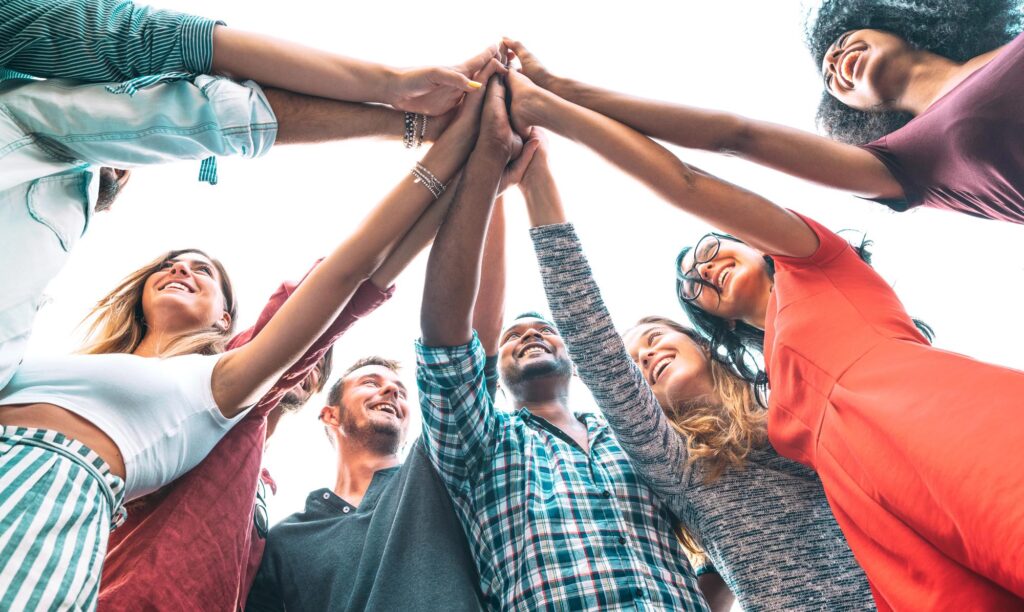 Multicultural group of people holding hands